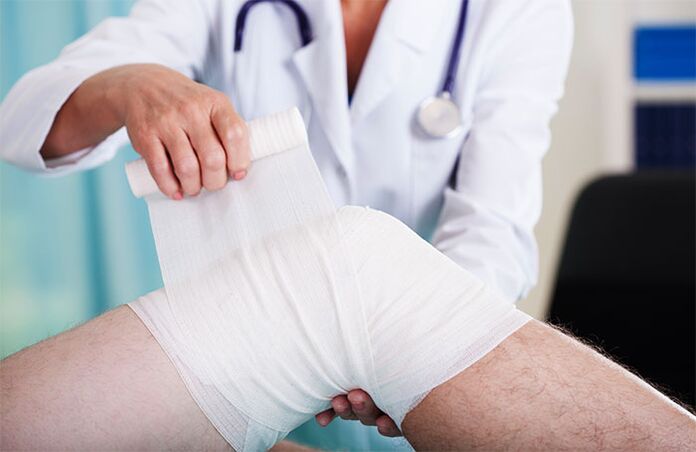 lékař bandážování kolenního kloubu s artrózou